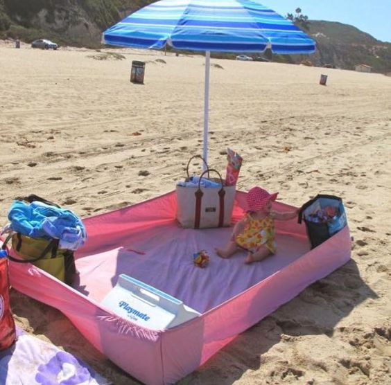 op het strand met soort box voor de baby