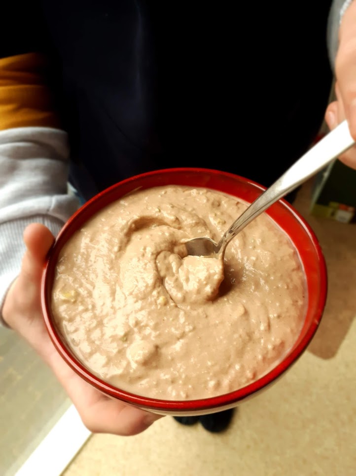 Smoothie bowl met cacaopoeder en pindakaas, in de handen van mijn oudste zoon.